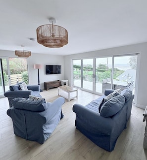 A modern living room with a large sofa set, a coffee table, and a television. - The Gables - Hot Tub- 4 Bedrooms- Sleeps 8- Dogs Allowed-Free parking for 2 cars (Aberdyfi)