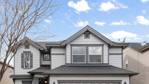 A two-story house with a garage, a front porch, and a small front yard. - Quiet Boise Retreat|Hot Tub•Game Room• 4BR (Boise)