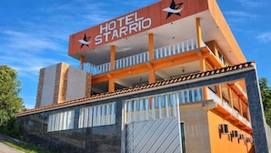 Un hotel llamado 'Hotel Starri' con un diseño moderno, múltiples balcones y una entrada destacada.