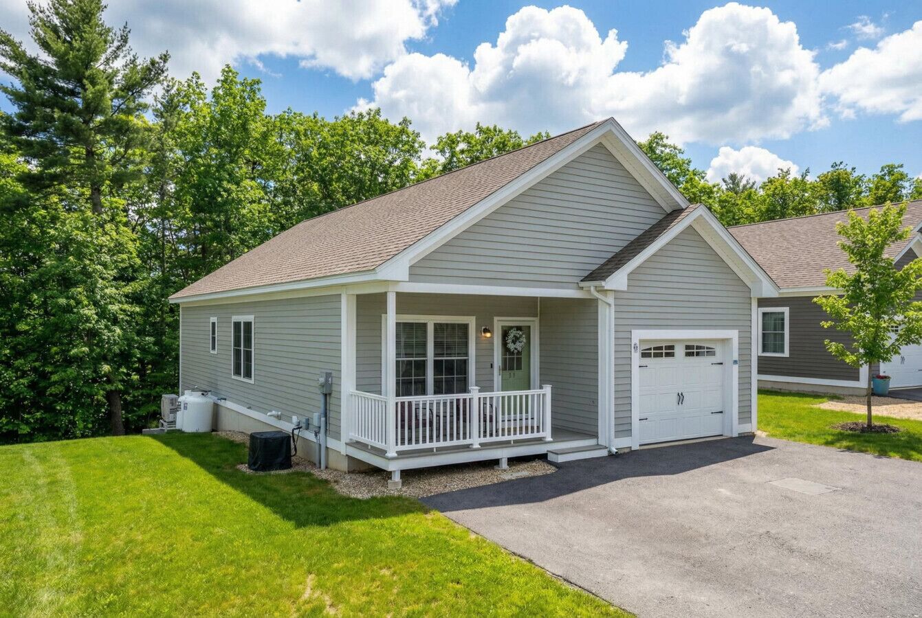 A single-story house with a front porch, a garage, and a well-maintained lawn.