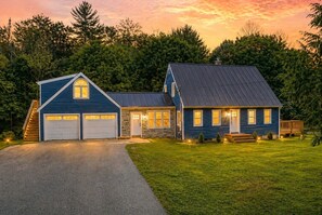 Une maison à deux étages avec un garage, un porche à l’avant et une allée.