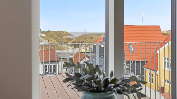 Un balcón con vistas a edificios y una playa.