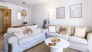 A living room with a sofa set, a coffee table, wall art, and a hanging light fixture. - La Palmera (Javea / Xàbia)