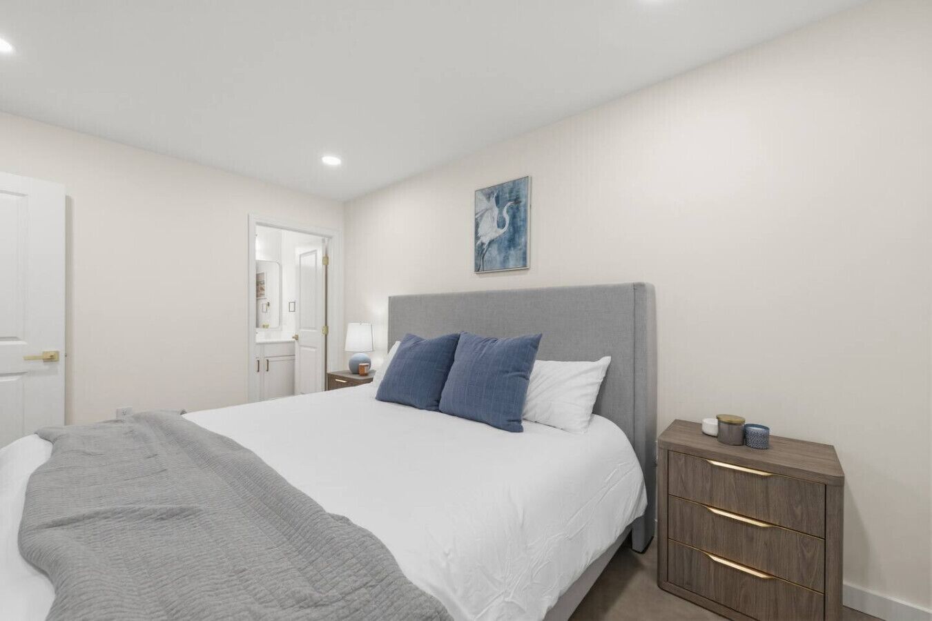 Une chambre à coucher avec un lit, une table de chevet et une commode.