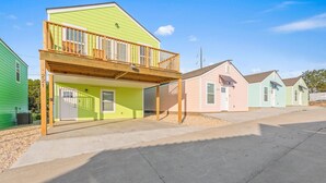 Ein Wohngebiet mit einem zweistöckigen Haus, das einen Balkon, eine Garage und eine Auffahrt besitzt.