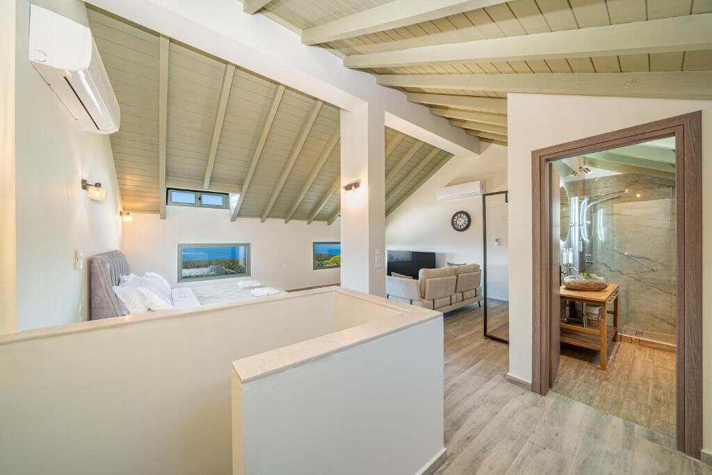 Un intérieur moderne avec un plafond haut, une grande fenêtre, un téléviseur à écran plat et un coin salon offrant une vue agréable.