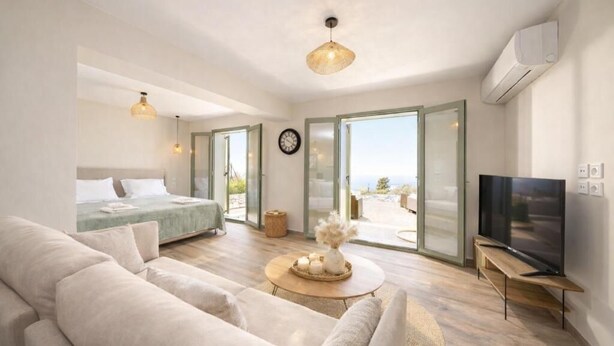 A modern bedroom with a bed, a TV, and a sofa. - HELLOSUMMER (Kefalonia)