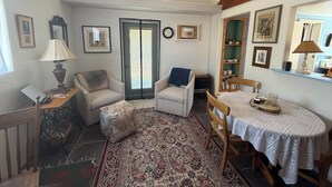 A cozy living room with a sofa, armchair, and a dining table with a lace tablecloth. - Jill's place is Cozy 2 bedroom cottage on a quiet dead end road, near Cortez. (Cortez)