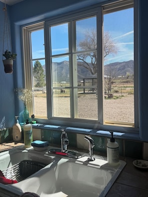 Une cuisine équipée d’une fenêtre, d’un évier et de divers produits de toilette.