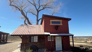 A small, rustic building with a wooden exterior, a metal roof, and a mounted cow head. - Jill's place is Cozy 2 bedroom cottage on a quiet dead end road, near Cortez. (Cortez)
