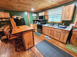 Une cuisine rustique avec des meubles en bois, un coin bar et une fenêtre offrant une belle vue.