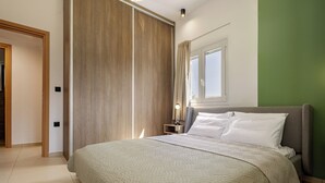 Un dormitorio moderno con una cama grande, una mesita de noche con lámpara y una puerta corredera de madera.