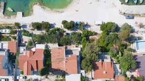 Ett flygbildsbild av ett kustområde med byggnader, en strand och båtar.