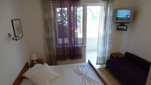 A room with a bed, a sofa, a television, and curtains. - Villa Azure Saplunara - One bedroom apartment (Saplunara)