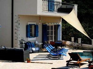 Ein zweistöckiges Gebäude mit Balkon, Außenbereich und Schwimmbad.