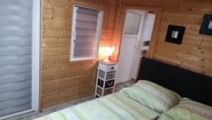 Una stanza in legno con un letto, una scrivania e un armadio.
