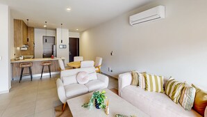 A modern apartment with a kitchen, dining area, and two sofas. - Gorgeous & Spacious Apartment with Balcony, Heated Pool - AC (Cabo San Lucas)