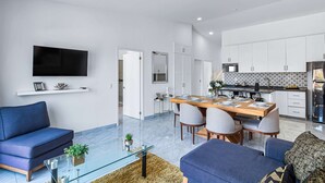Un salon moderne avec un canapé, une table basse et un téléviseur.