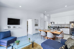 A modern living room with a sofa, coffee table, and TV. - Morgan Residences 607A @ Boutique Hotel with pool, gym, spa (Cabo San Lucas)