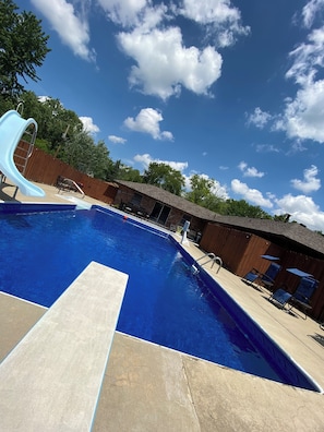 A swimming pool with a slide, a wooden deck, and a brick building in the background. - Entire home in Indianapolis Indiana
10guest, 3 bedrooms,5 beds,2 baths, pool. (Indianapolis)