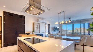 Una cucina moderna con isola centrale, mobili in legno scuro e un'ampia finestra con vista sulla città.