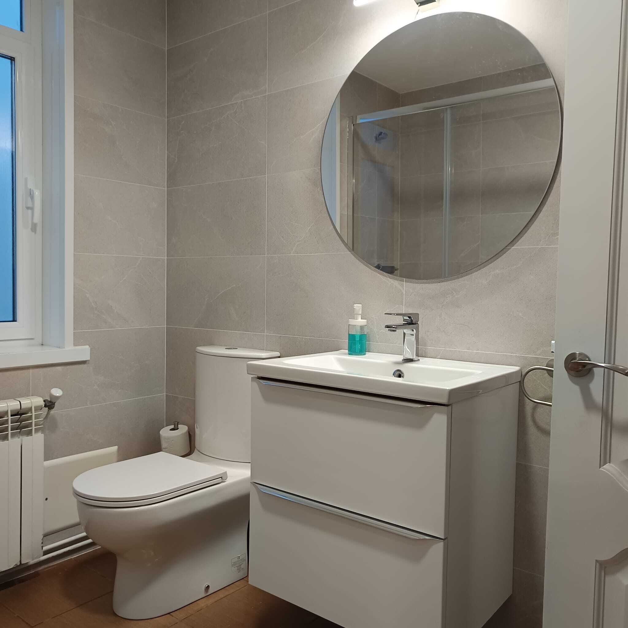Ein Badezimmer mit Toilette, Waschbecken und Spiegel.