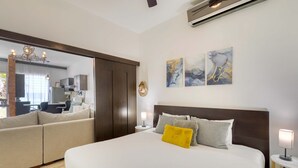 Ein Schlafzimmer mit einem großen Bett, einem Sofa, einem Schreibtisch und einem Spiegel.