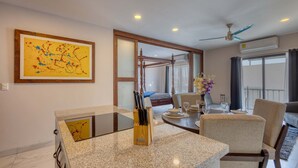 Una habitación de hotel moderna con zona de comedor, cama y balcón.