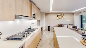 Eine moderne Küche mit Holzausstattung, einem Gasherd und einer Mikrowelle.