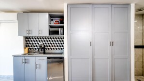 Una cucina moderna con mobili grigi, un forno a microonde e una macchina per il caffè.