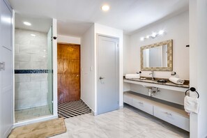 A modern bathroom with a shower, vanity, and a large mirror. - Hotel room with ocean-view rooftop infinity pool, AC, & gym - dog-friendly (Cabo San Lucas)