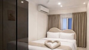 Ett modernt hotellrum med en stor säng, en glasvägg och en luftkonditioneringsanläggning.