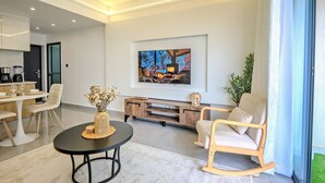 Uma sala de estar moderna com uma televisão de tela plana e uma área de jantar.