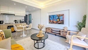 Uma sala de estar moderna com área de jantar, cozinha e sistema de entretenimento.