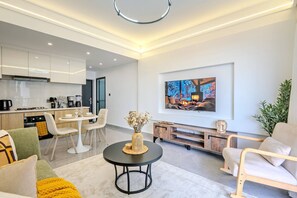 Un salon moderne comprenant un coin repas, une cuisine et un espace dédié aux loisirs.