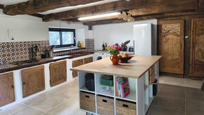 Una cocina con armarios de madera, una isla central y salpicadero de azulejos.