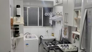 Una cocina compacta con estufa a gas, un lavamanos y una ventana.