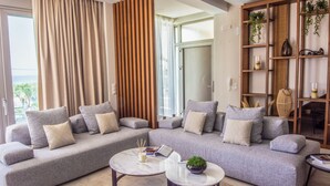 Ein modernes Wohnzimmer mit einem grauen Ecksofa, zwei runden Couchtischen und einer Holzregalanlage mit Pflanzen.