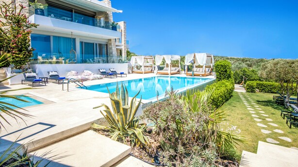 Ein modernes, zweistöckiges Gebäude mit Pool, Außenbereich und einem gepflegten Garten.