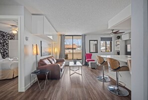 Una sala de estar moderna con un sofá, una mesa de centro y taburetes de bar.