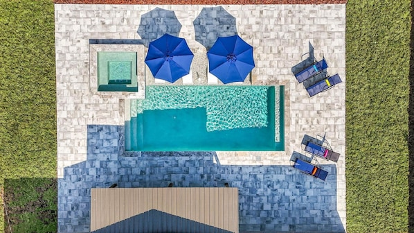 A rooftop pool with blue umbrellas, lounge chairs, and a wooden deck. - Newly Renovated Spacious 5-bedroom house with Pool and Hot Tub in Largo (Largo)
