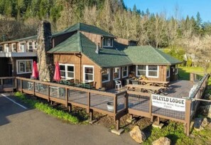 A lodge with a green roof, wooden exterior, and a sign indicating it offers beer and wine.