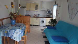 Un espacio habitable compacto con comedor, cocina y sofá.