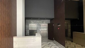 En moderne lobby med marmorgulv, et receptionsskrank og en loftlampe.