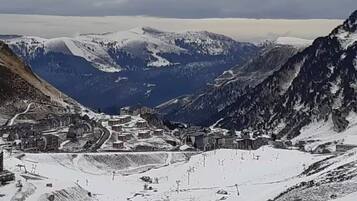Un paysage montagneux comprenant une station de ski, avec des remontées mécaniques et des bâtiments.