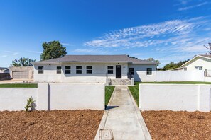 A single-story house with a front entrance, a visible garage, and a clear sky. - Walking distance to City of Hope -Bright 4BR -Private Patio Outdoor Living (Duarte)