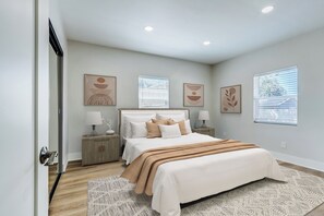 A bedroom with a large bed, two bedside tables, a nightstand, and a window with blinds. - Walking distance to City of Hope -Bright 4BR -Private Patio Outdoor Living (Duarte)