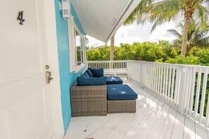 A balcony with wicker furniture and a white railing. - Sunrise Views & Beach Access | BBQ + Free Parking (Fort Pierce)
