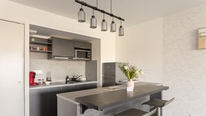 Eine moderne Küche mit einer zentralen Kochinsel, Barhocker, einer Mikrowelle und einer Kaffeemaschine.