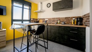 Una cocina con ventana, un reloj y una cafetera.